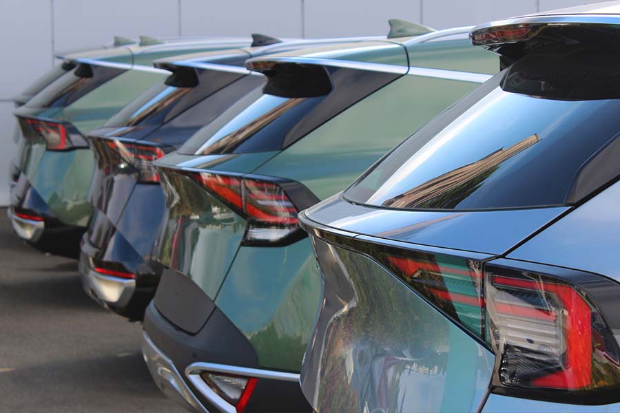 The rears of a fleet of green and gray hatchbacks used for business purposes - staplesagency.com